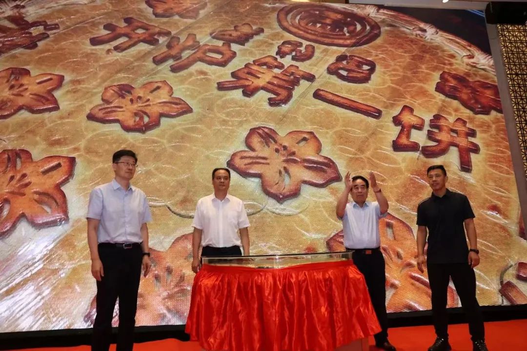 中共天橋區(qū)委副書記、區(qū)長張慶國、濟南市商務局黨組成員、副局長李曉軍、濟南市市場監(jiān)管局副局長馮愛民與濟南益康總公司黨委書記、董事長王忠本共同為直徑1.3米重達256斤的“齊魯月餅王”揭幕